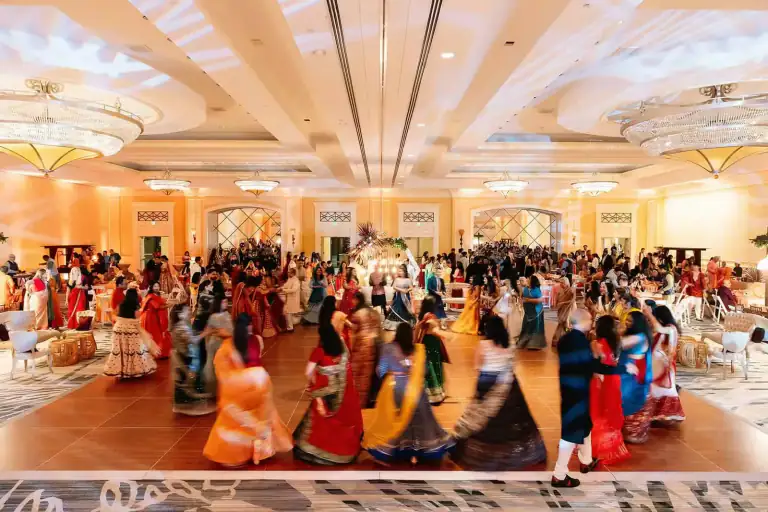 South Asian couple grand entrance on wedding dance floor with Desi Decibel DJ and uplighting